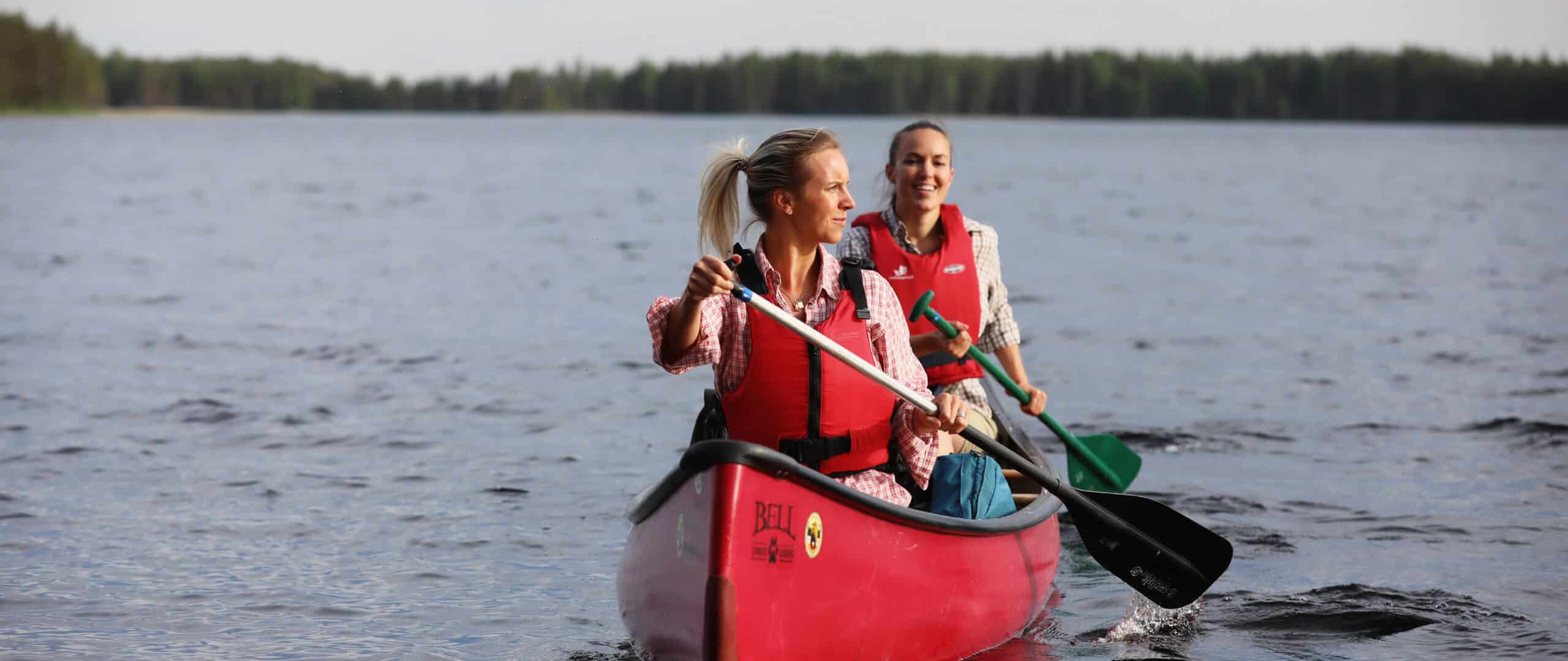 Two women paddling on the lake in Finland