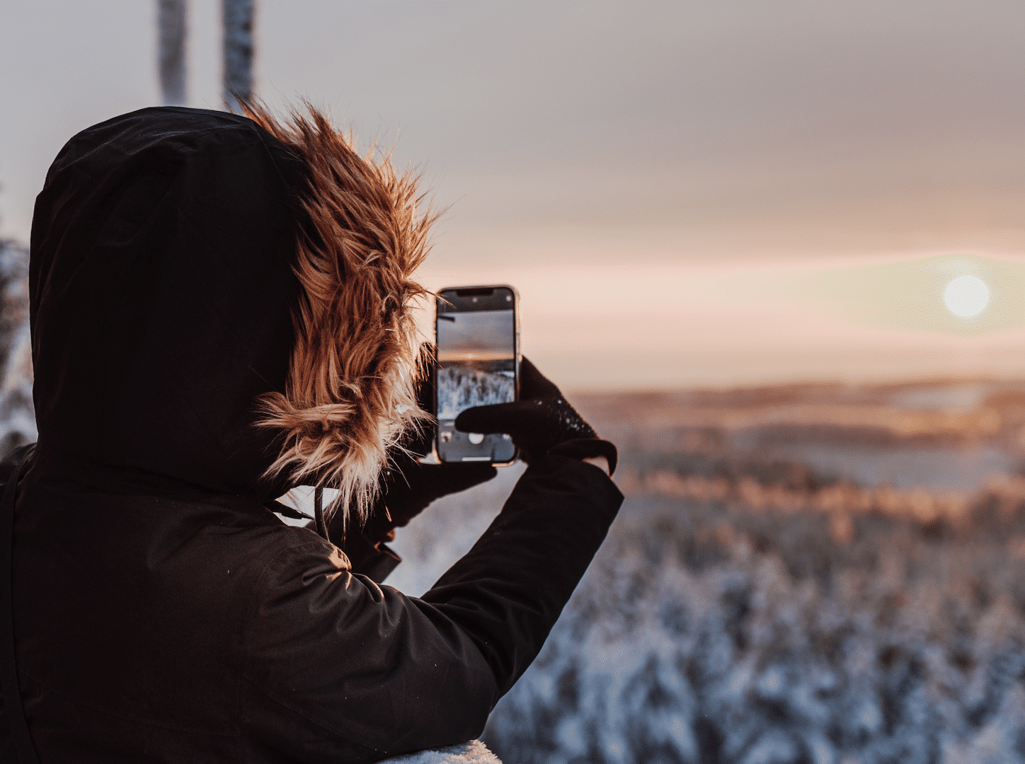 Person taking a photo from winter landscape in Finland