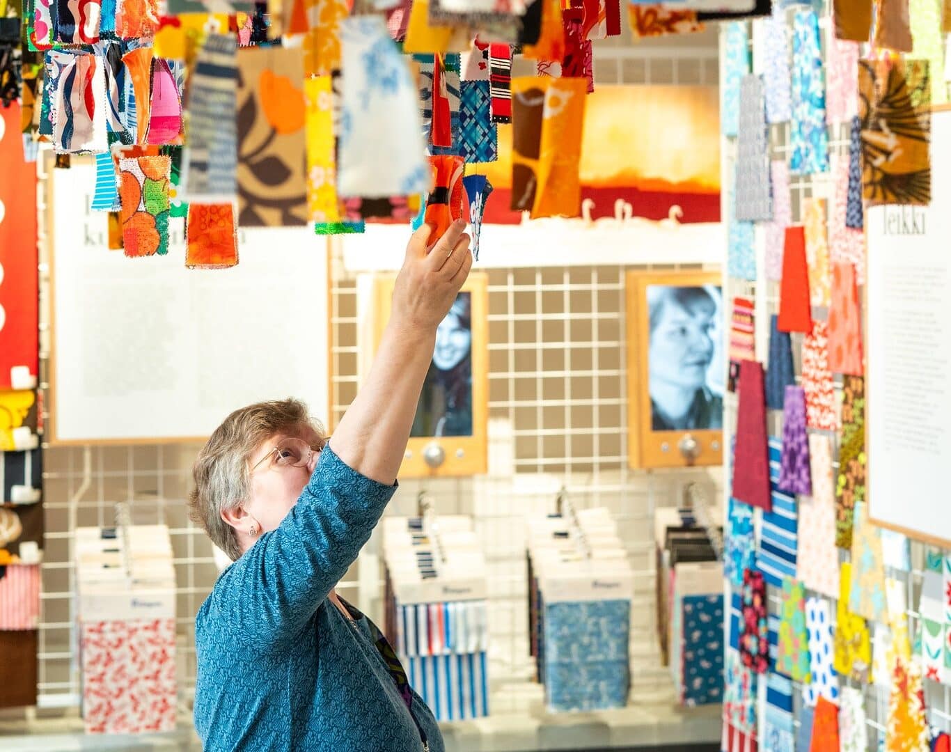 Woman touching colorful textile examples in Pattern Center